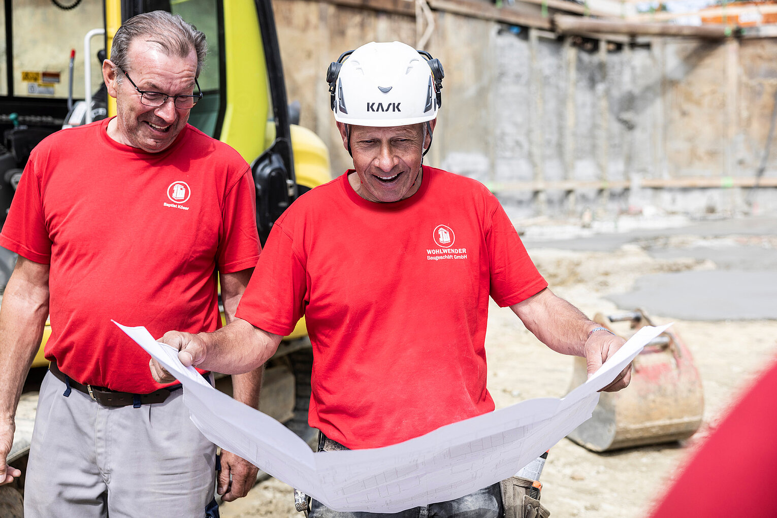 Bauleitung hält Bauplan in der Hand