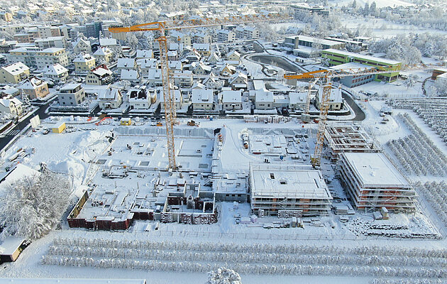 Eine Drohnenaufnahme einer Winterbaustelle mit Schnee bedeckten Häusern